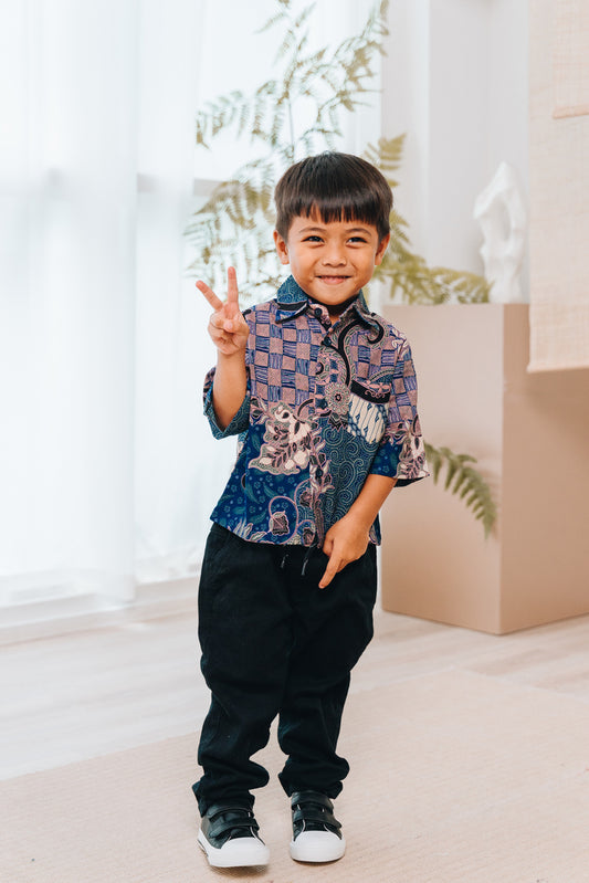 The Boys Jiwa shirt is a mix of traditional and floral elements of the parang print. This short-sleeved button-up shirt features a classic collar, along with a front chest pocket. Made from premium cotton dobby for a breathable and relaxed drape, the shirt requires minimal to no ironing care.This print comes in 2 colours, blue and burgundy.